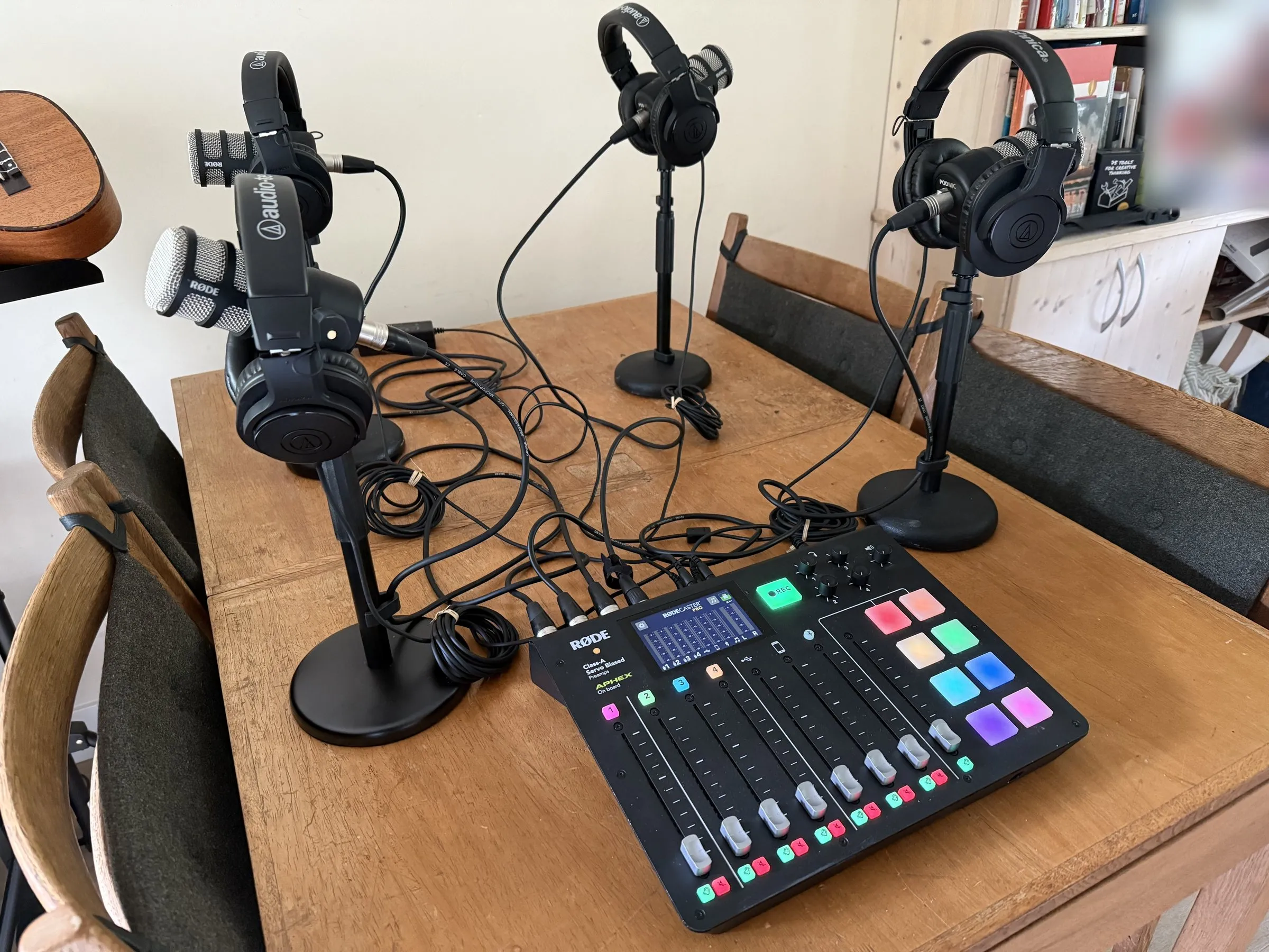 De huurset op tafel: een Rødecaster Pro met vier Røde PodMics op tafelstatieven, elk met een Audio-Technica-koptelefoon