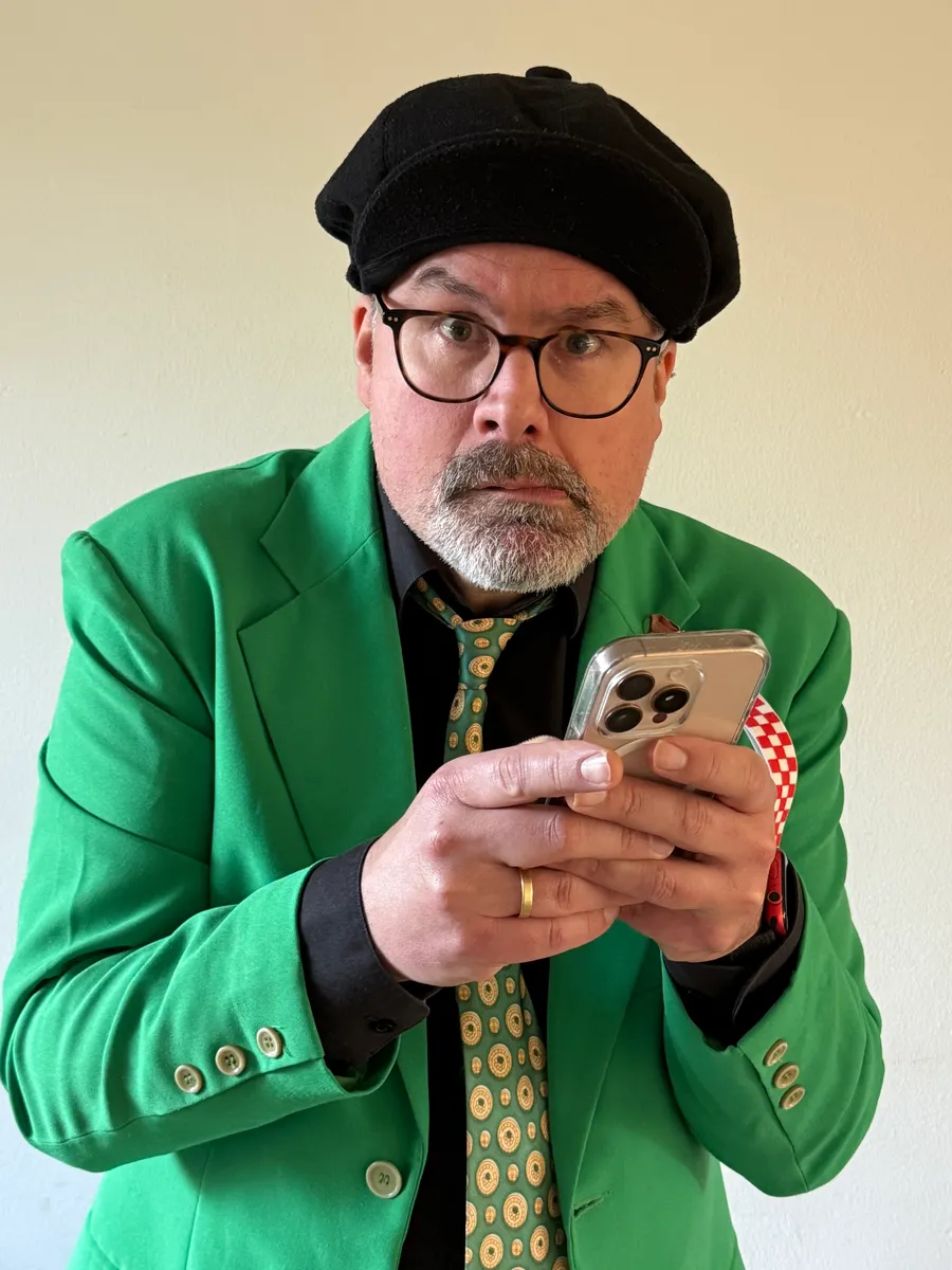 Jöran als carnavalsartiest Sjefke, met baret, groen colbert en telefoon